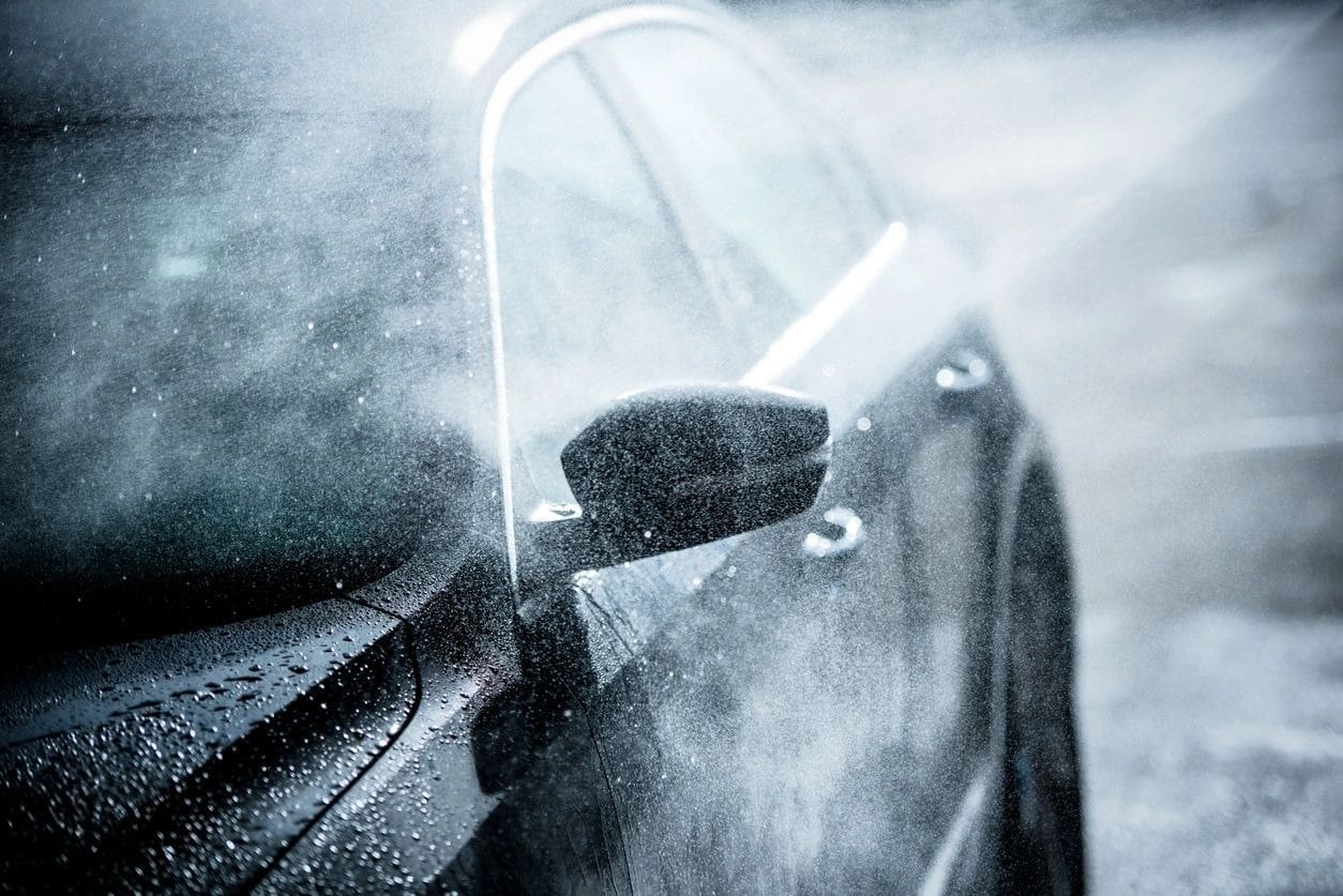 A car is being washed in the rain.